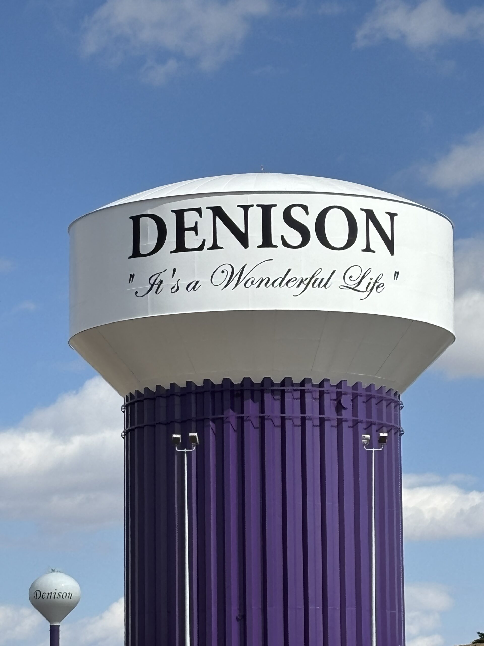 113 Water tower with 'DENISON It's a Wonderful Life' text against a blue sky.